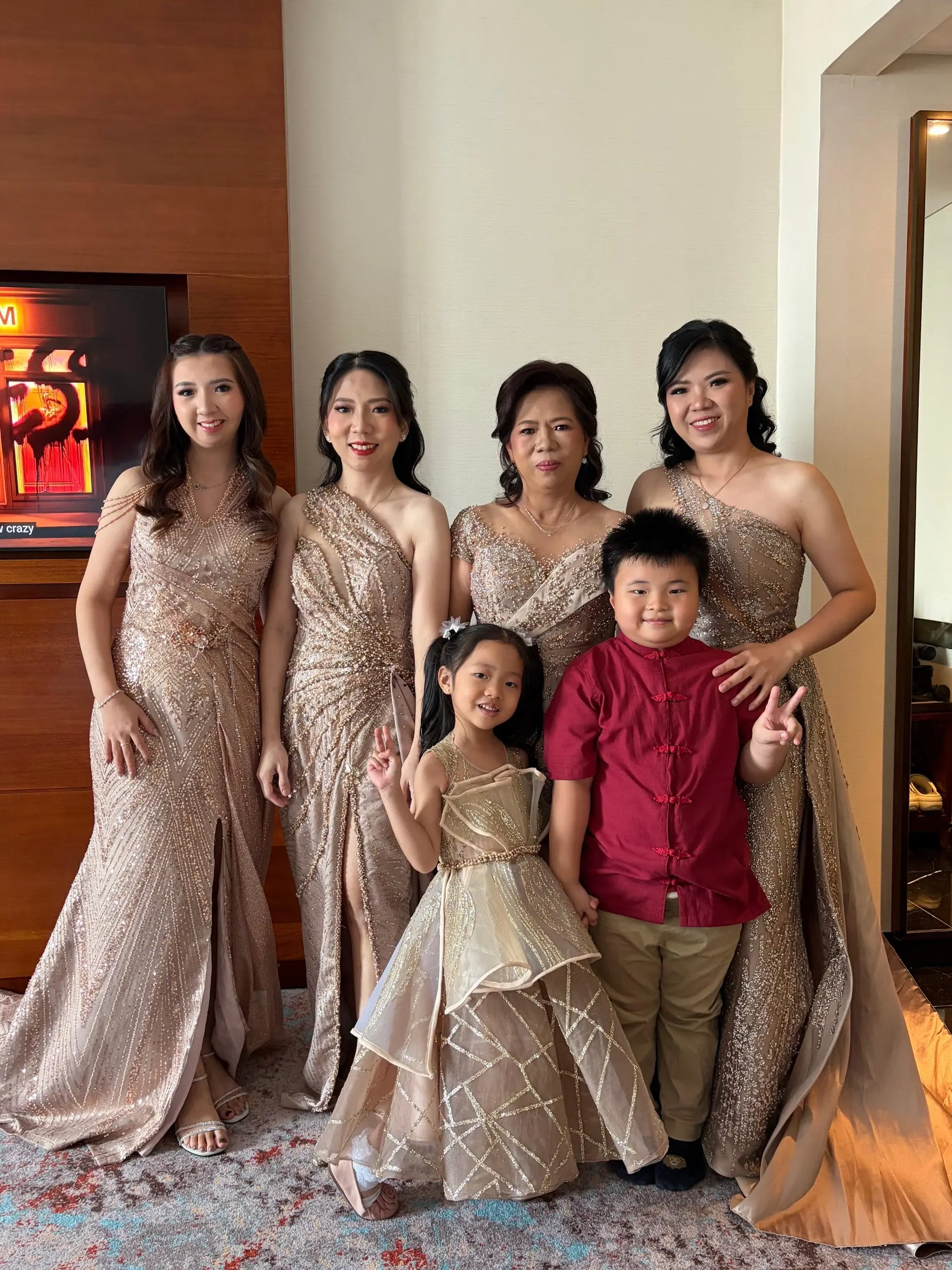 Keluarga dengan gaun pesta bronze, termasuk anak perempuan dengan gaun senada