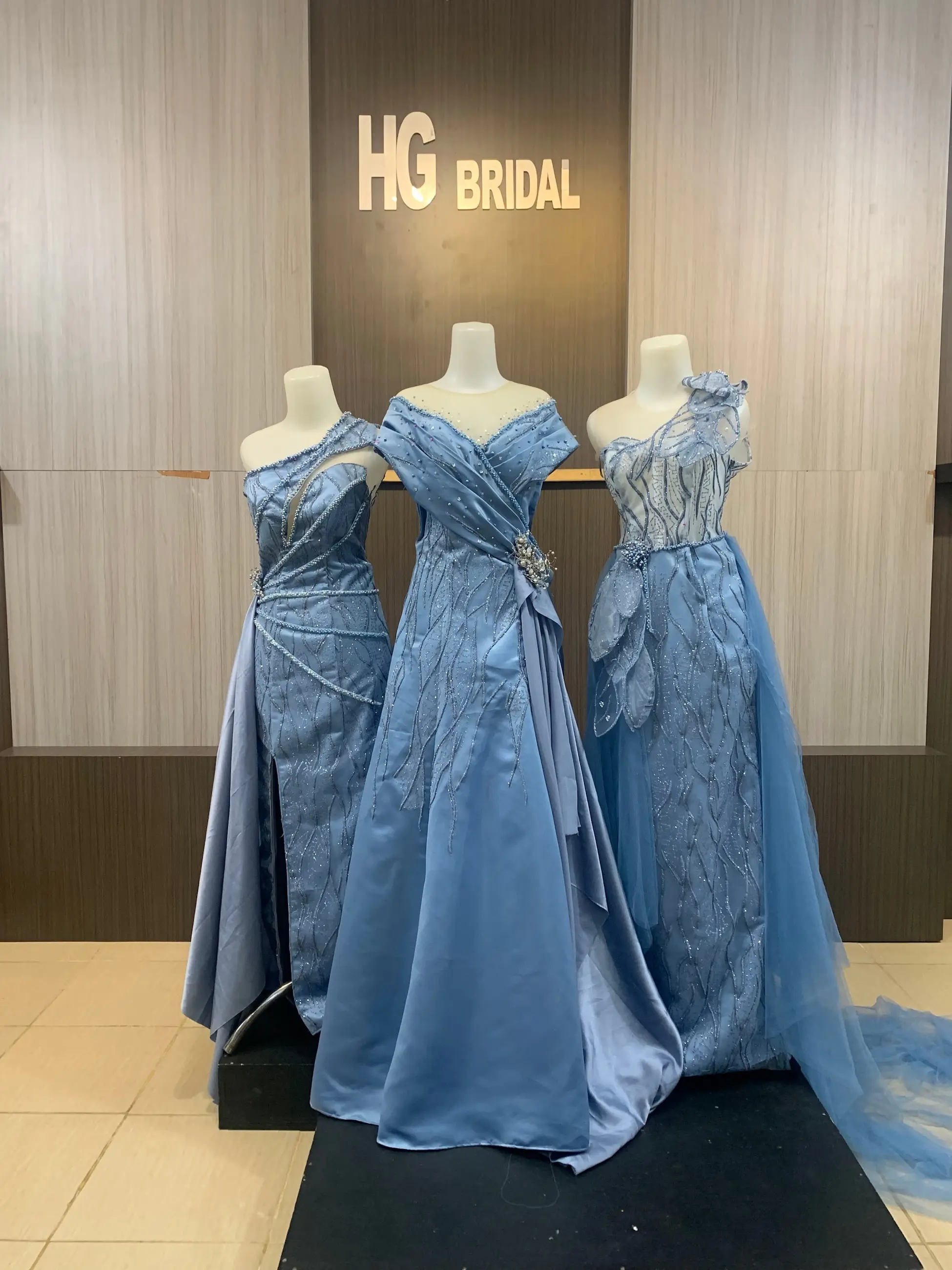 Tiga gaun pesta dusty blue di manekin butik HG Bridal