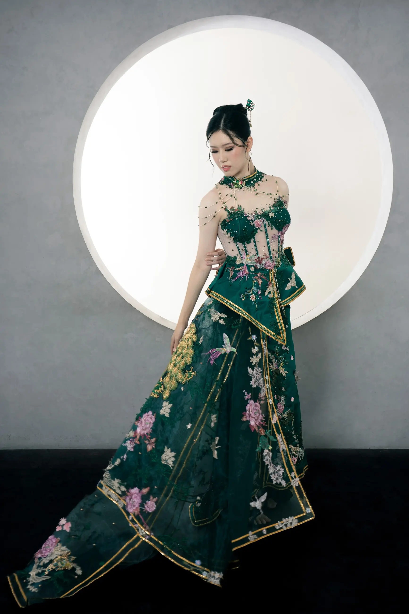 Cheongsam emerald berekor di depan latar bulat