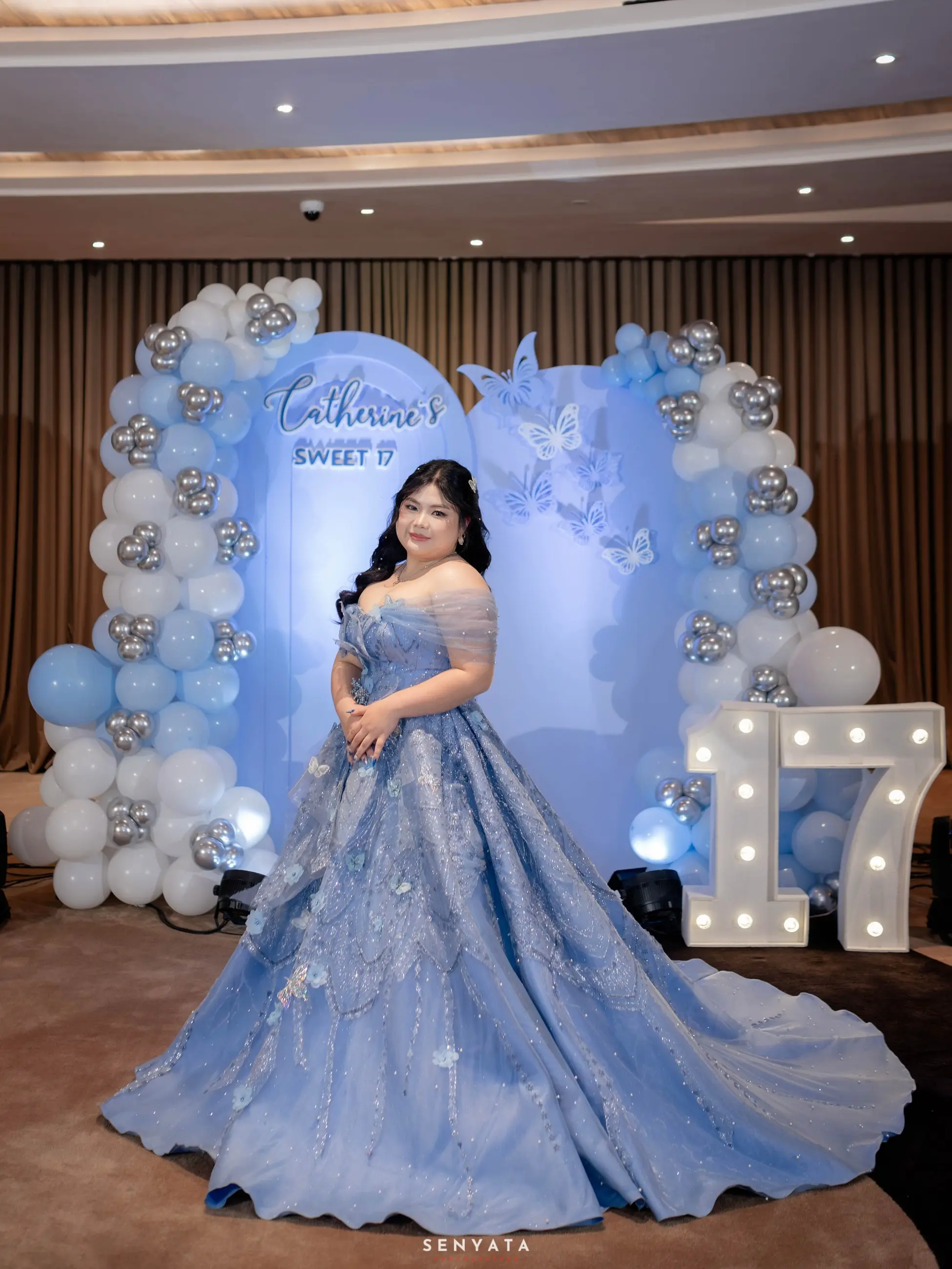 Ballgown biru di depan dekorasi angka 17
