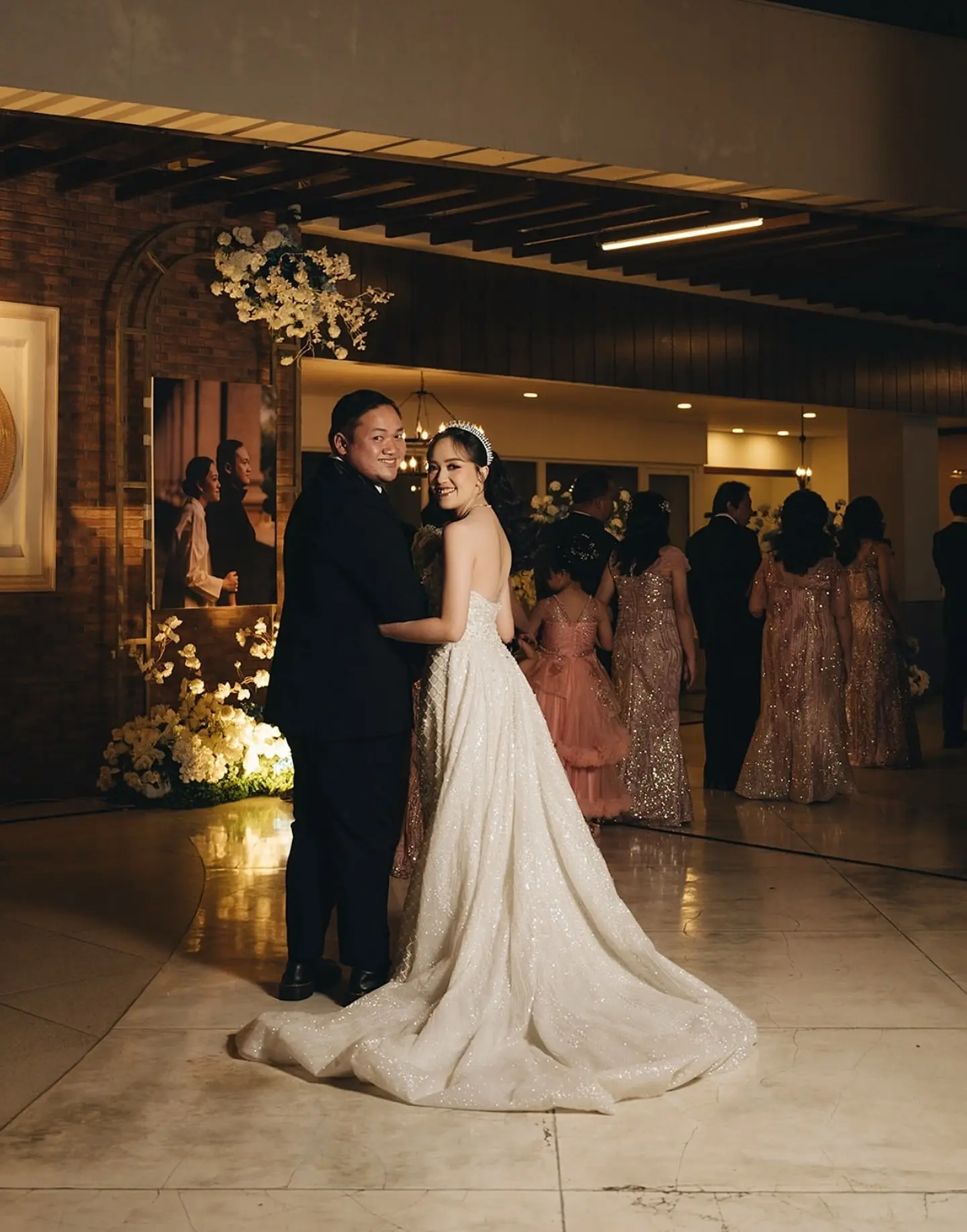 Pengantin dengan gaun berekor panjang di lobi gedung